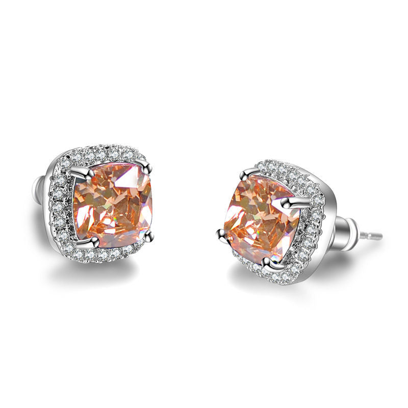 Pair of peach-colored gemstone earrings with silver settings on a white background