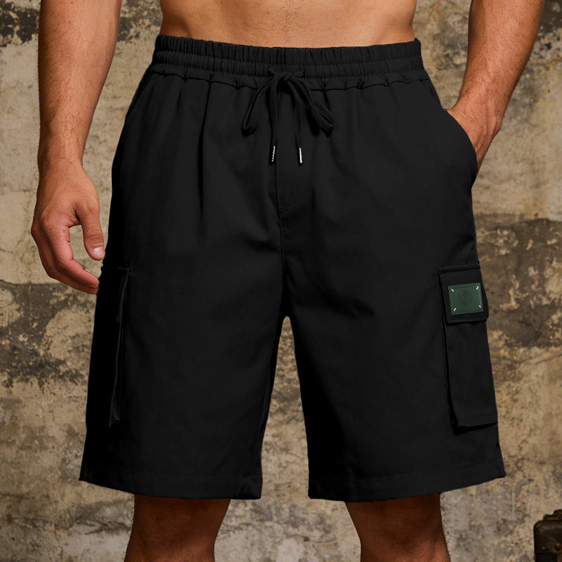 Black cargo shorts with a patch on a textured background