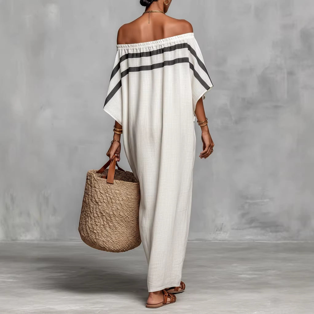 Woman wearing a white off-shoulder dress with black stripes, holding a woven bag against a gray background.