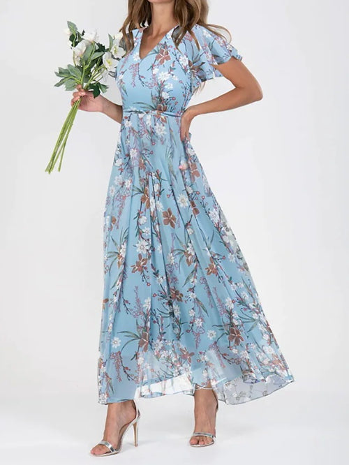 Woman wearing a blue floral dress holding flowers on a white background