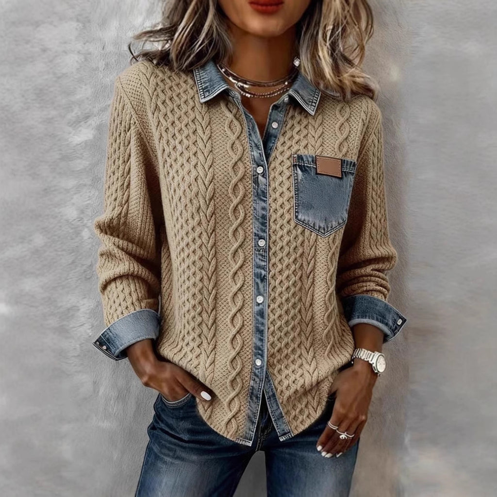 Person wearing a beige cable knit sweater over a denim shirt with a gray background