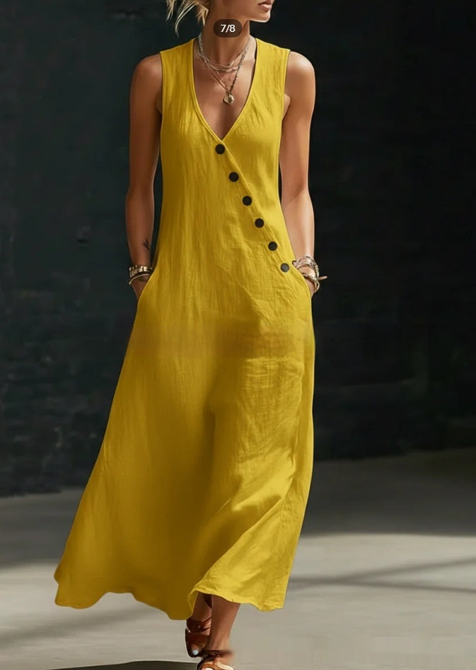 Woman wearing a yellow sleeveless dress with buttons against a dark background