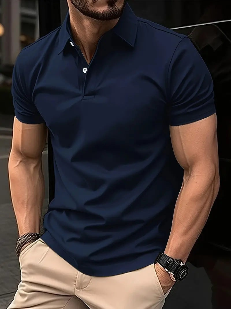 Man wearing a navy blue polo shirt and beige pants with a blurred background