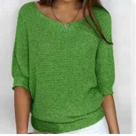 Green knitted sweater worn by a person on a white background