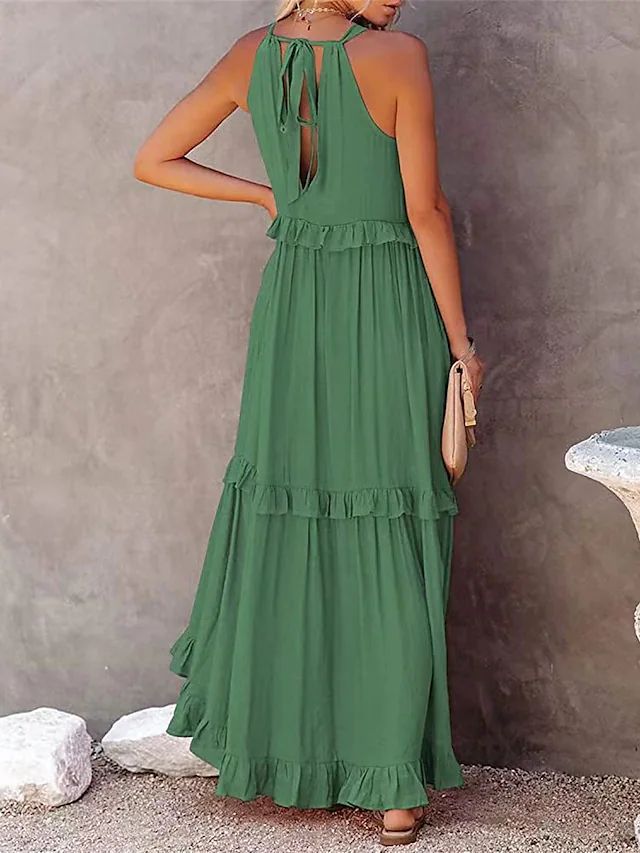 Green dress with ruffled layers worn by a person against a neutral background