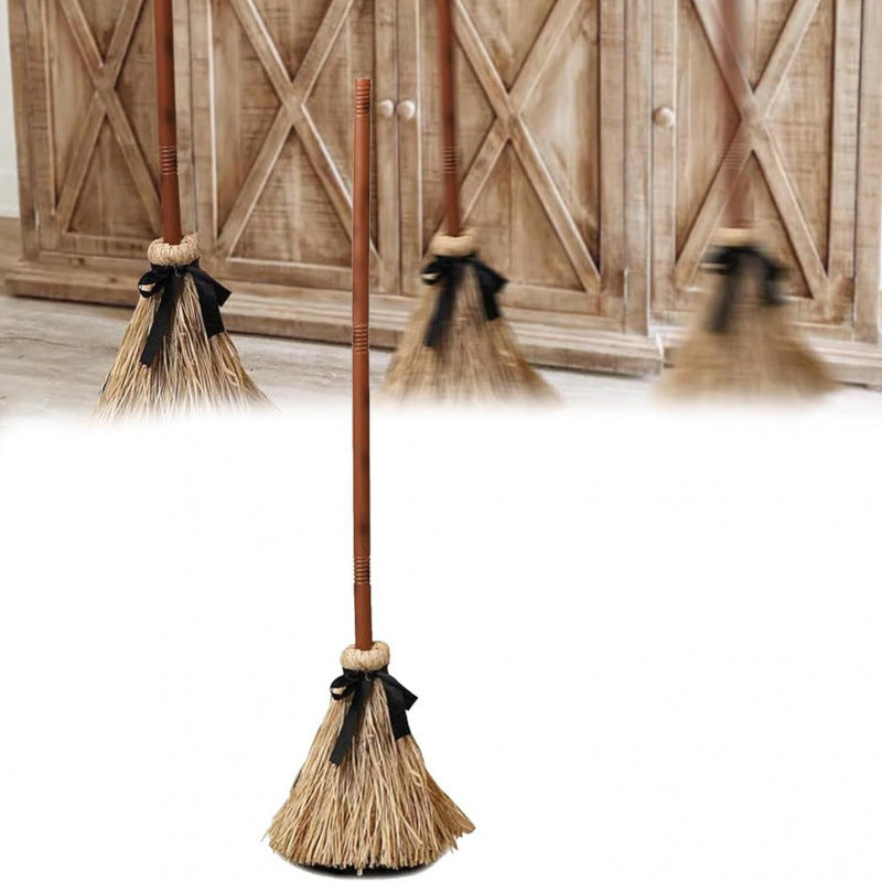 Set of brooms with black ribbons against a wooden background
