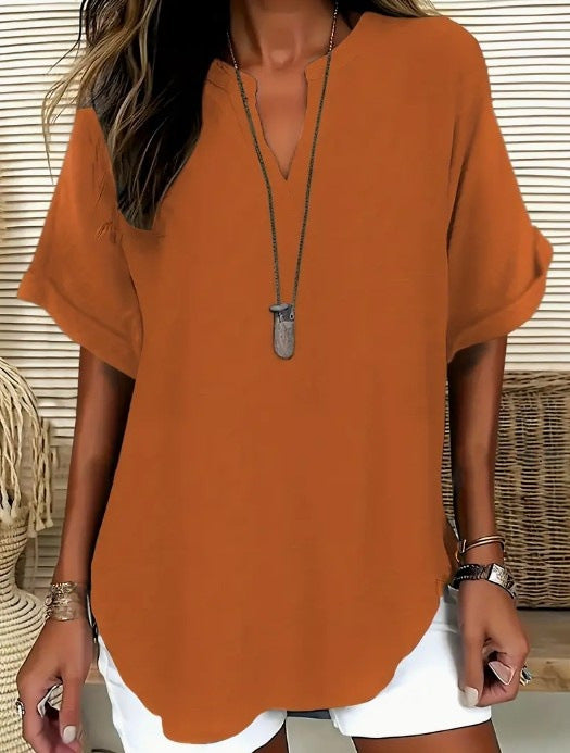 Person wearing a rust-colored blouse with a neutral background