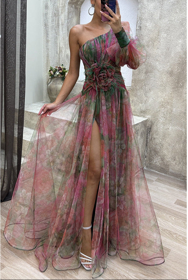 Woman wearing a floral one-shoulder dress with a high slit, standing in a room.