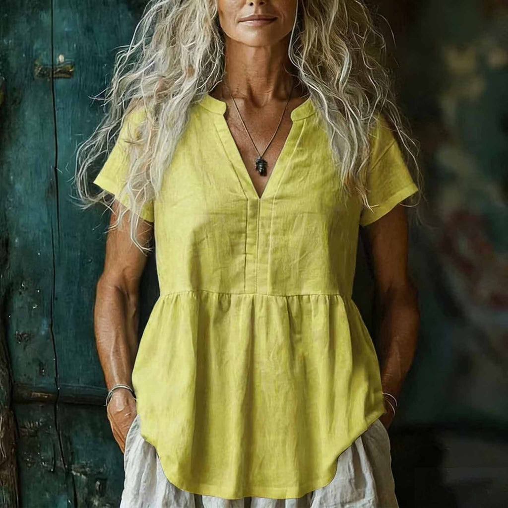 Woman wearing a yellow linen top with a blurred background