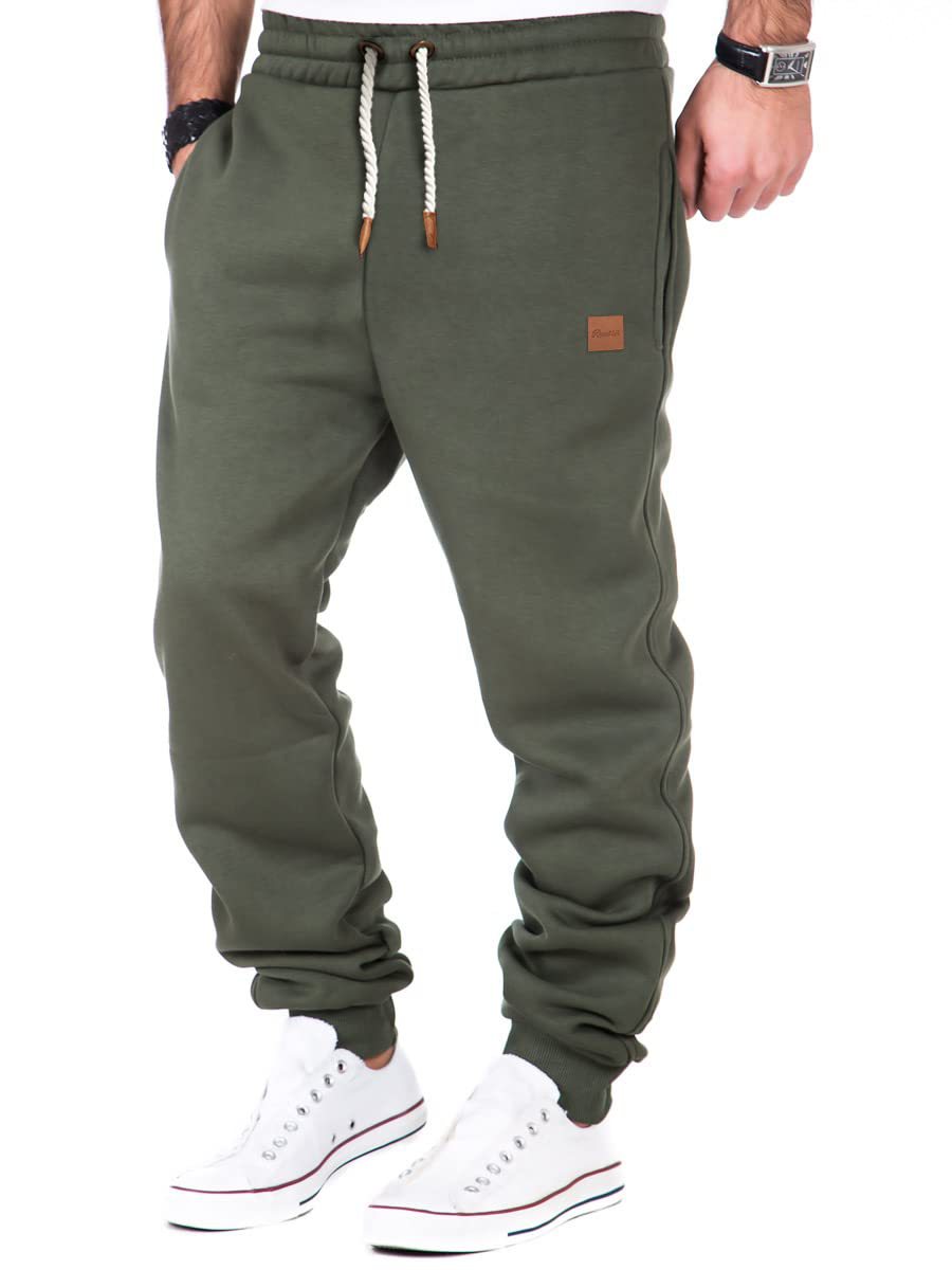 Green sweatpants worn by a person on a white background
