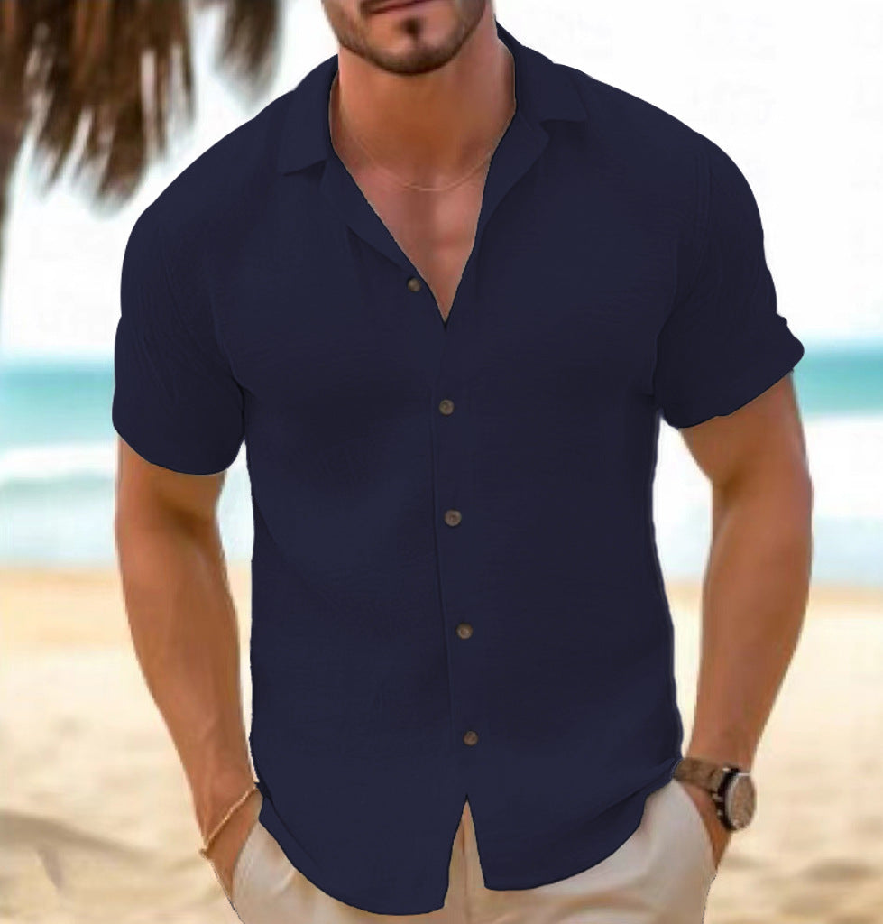 Man wearing a navy blue short-sleeve shirt on a beach