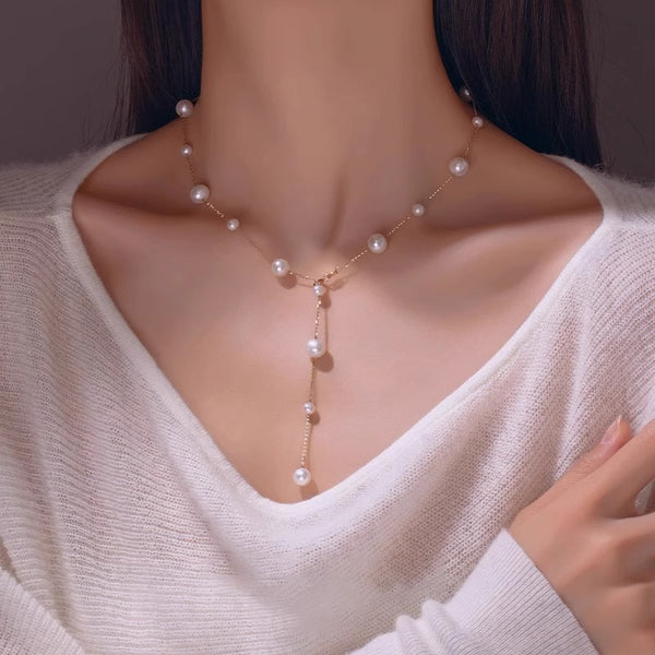 Pearl necklace worn by a person in a white sweater