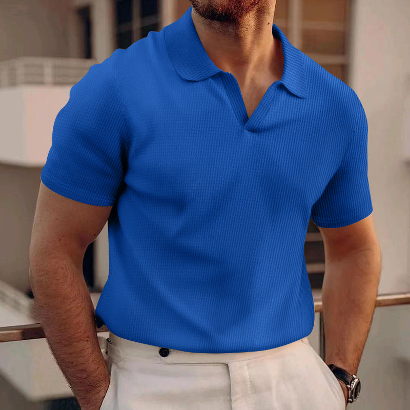 Person wearing a blue polo shirt with a blurred background