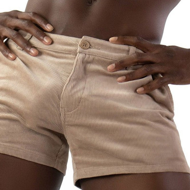 Beige corduroy shorts worn by a person with hands on hips against a white background