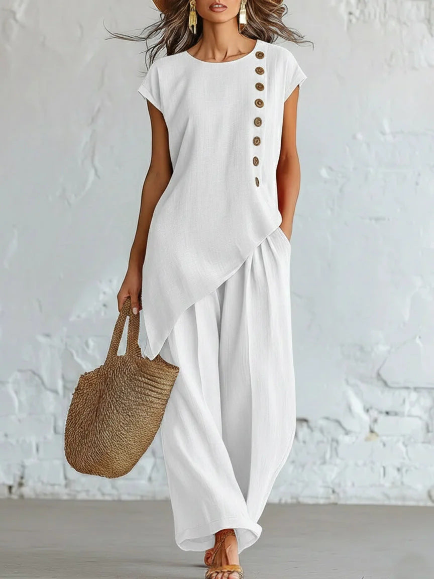 Woman wearing a white outfit with a textured white wall background