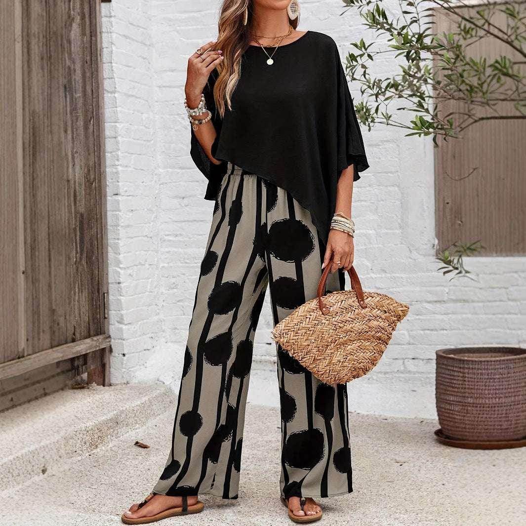 Woman in ZA-Zola chic black top and wide-leg patterned pants, holding a straw bag