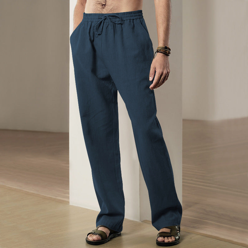 Person wearing blue pants standing against a neutral background