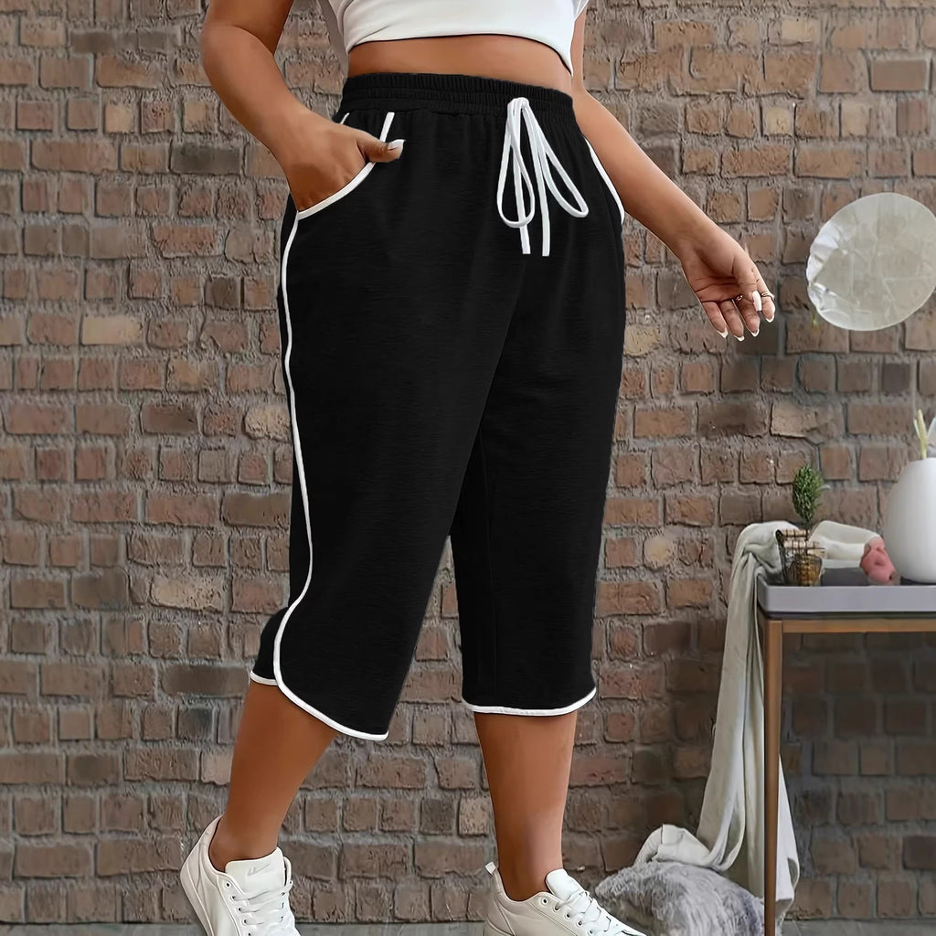 Person wearing black shorts with white trim against a brick wall.
