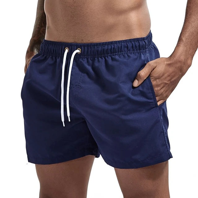 Navy blue swim shorts with a white drawstring on a white background