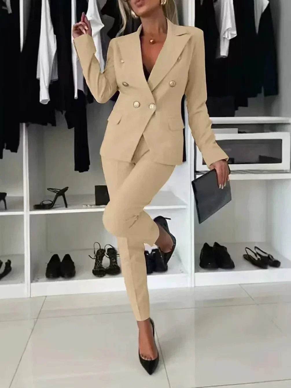 Woman modeling beige double-breasted blazer suit with black heels in chic ZA-Zola showroom