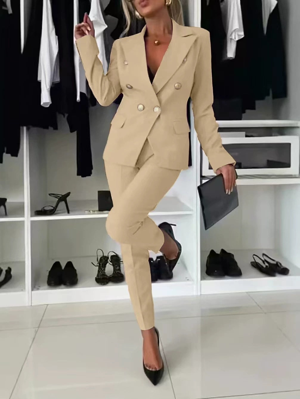 Person wearing a beige suit in a room with shelves and shoes.