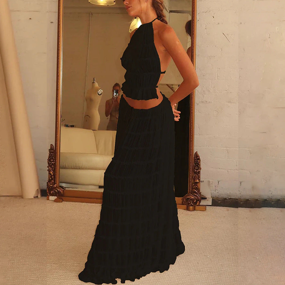 Woman wearing a black dress standing in front of a mirror.