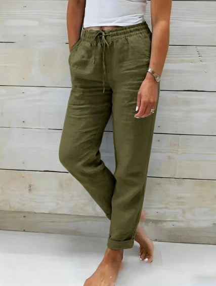 Person wearing olive green pants with a white background