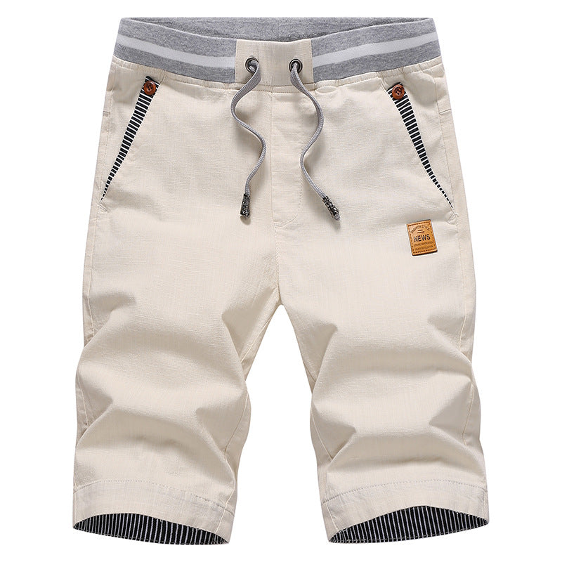 Beige shorts with a drawstring and brand logo on a white background