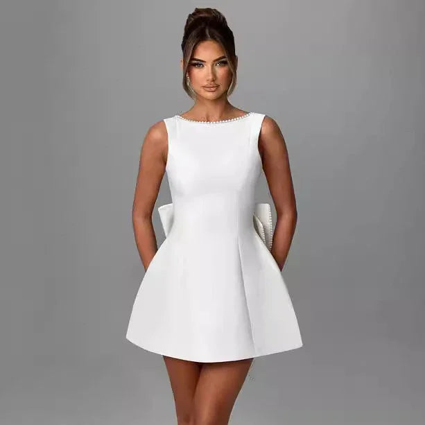 Woman wearing a white dress against a gray background
