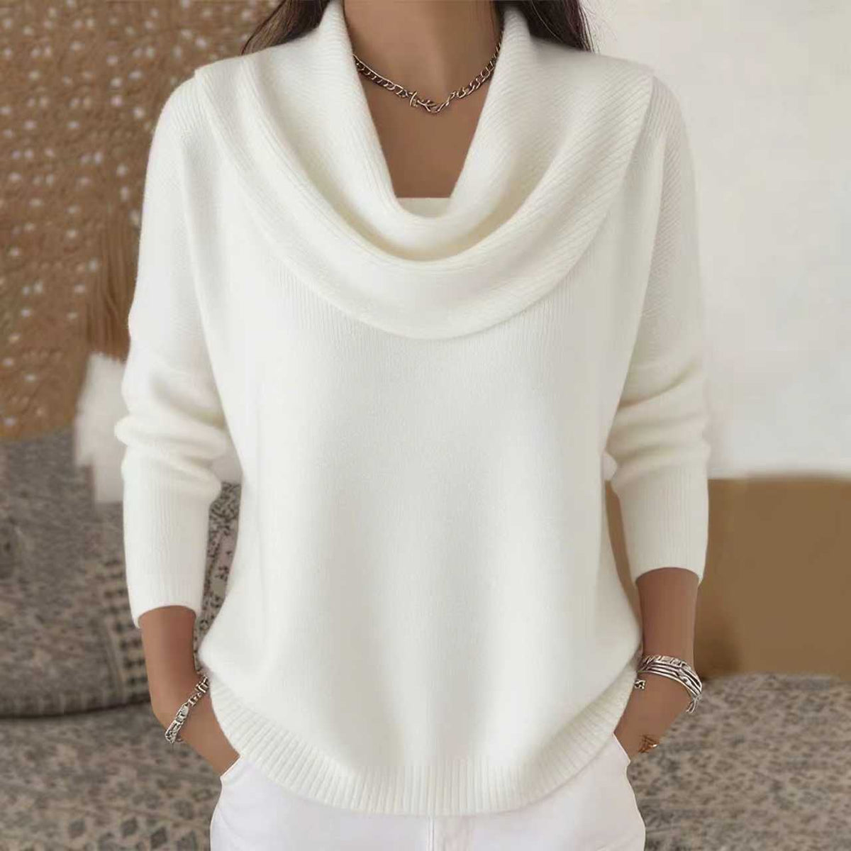 White sweater worn by a person with a blurred background