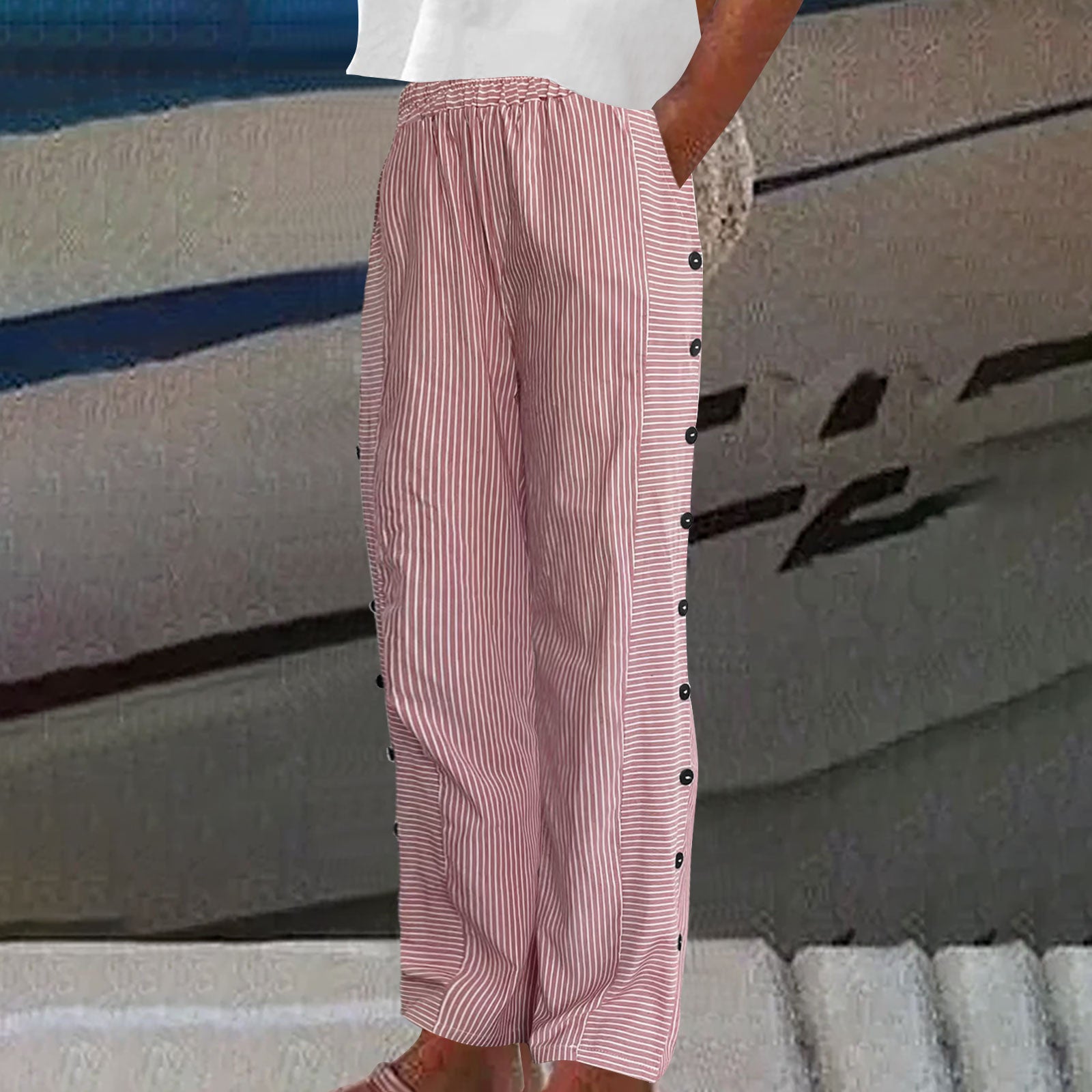 Person wearing pink striped pants with black buttons against a blurred background