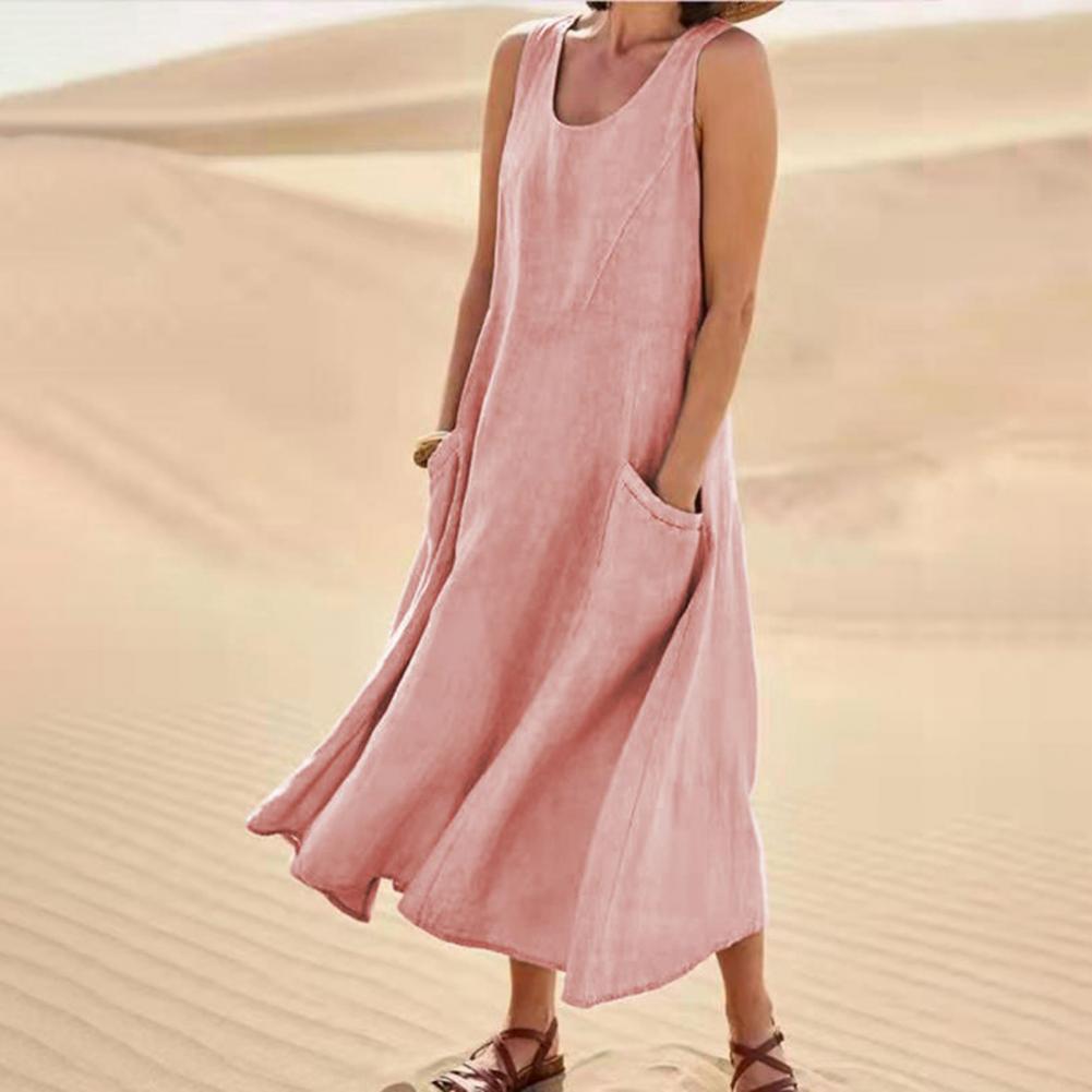 Person wearing a pink dress standing in sand dunes