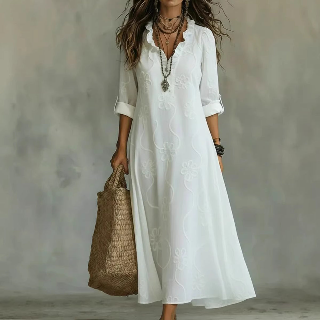 Woman wearing a white dress holding a woven bag against a neutral background