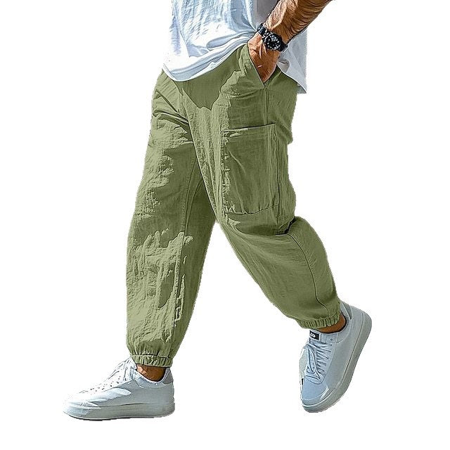 Person wearing green cargo pants and white sneakers on a white background