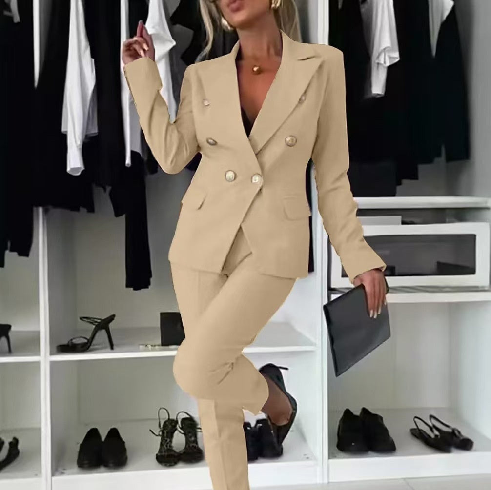 Woman in a beige suit standing in a closet with shoes and clothing around.