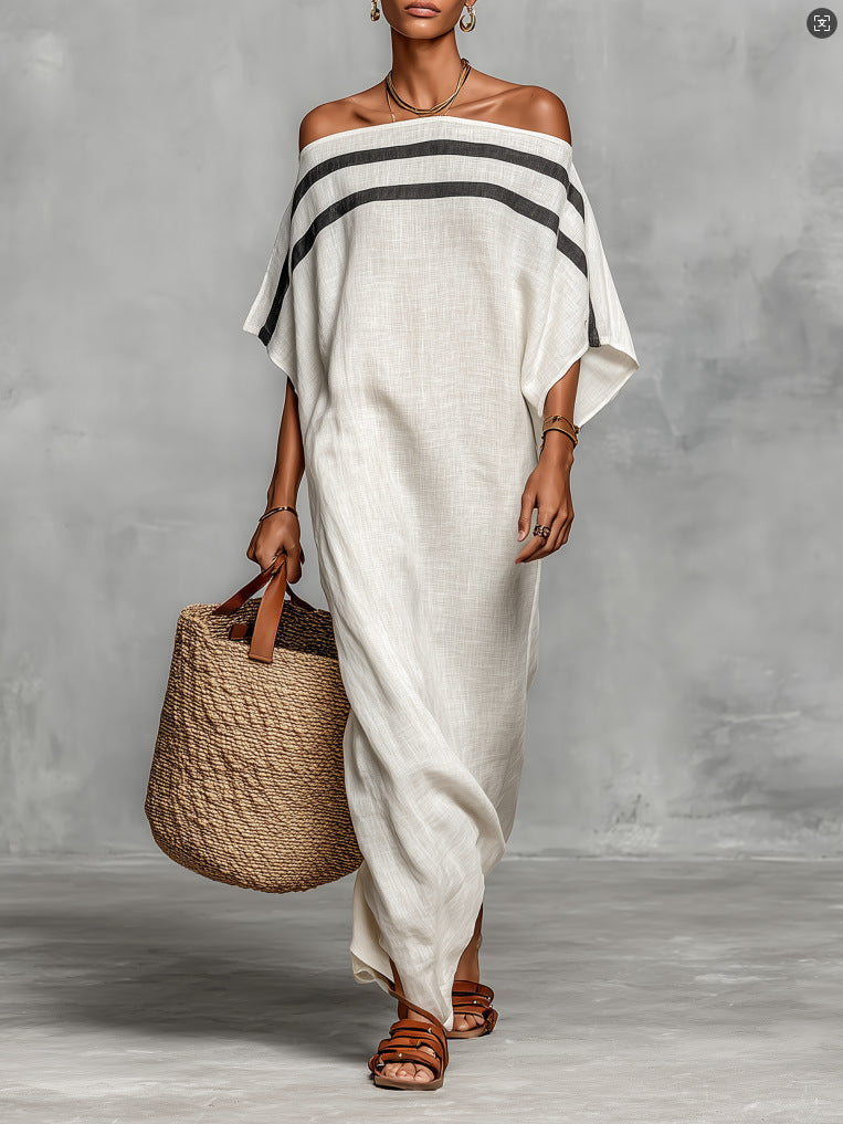 Woman wearing a white off-shoulder dress with black stripes, holding a woven bag against a gray background.