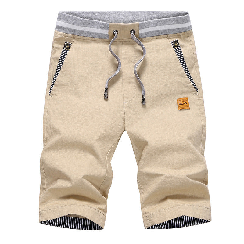 Beige shorts with gray drawstring and striped accents on a white background
