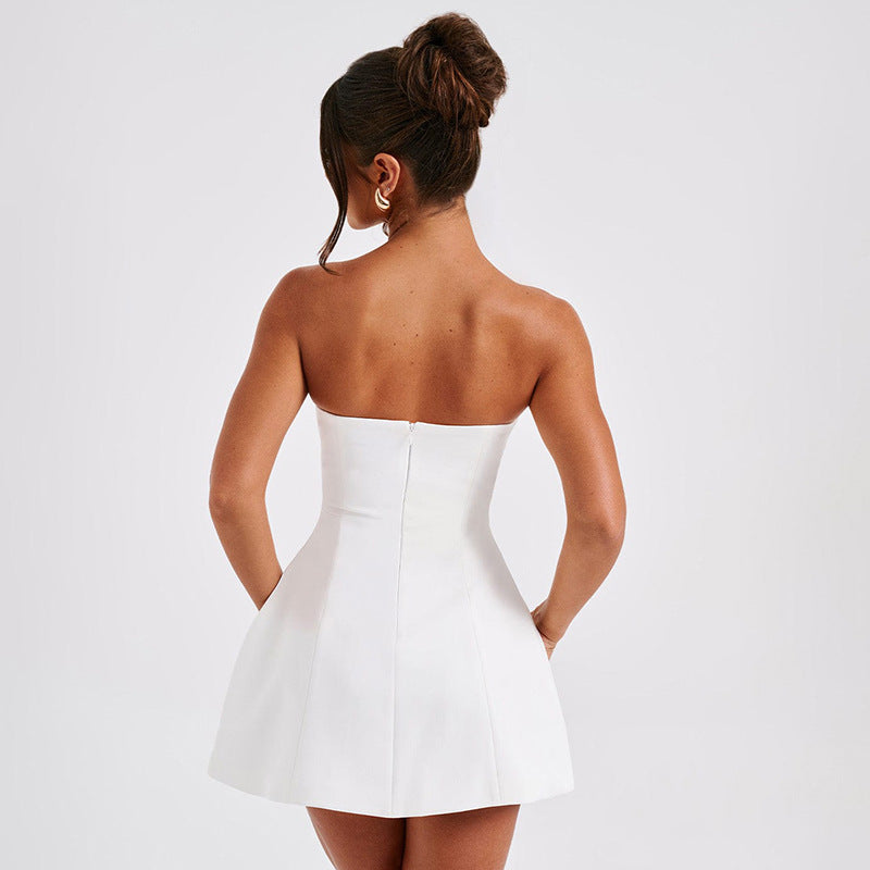 Woman wearing a white strapless dress on a plain background