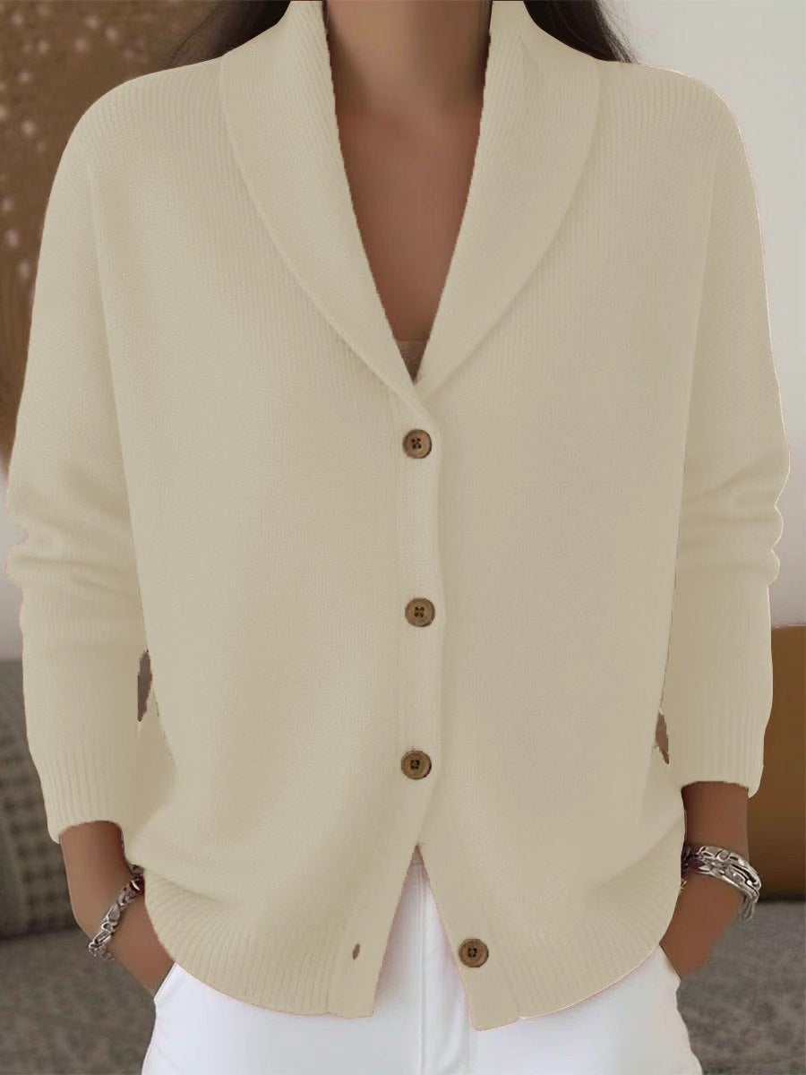 Beige cardigan with brown buttons worn by a person, blurred background