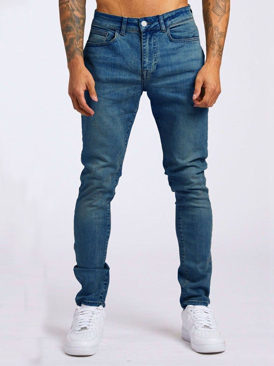Person wearing blue jeans and white sneakers on a white background