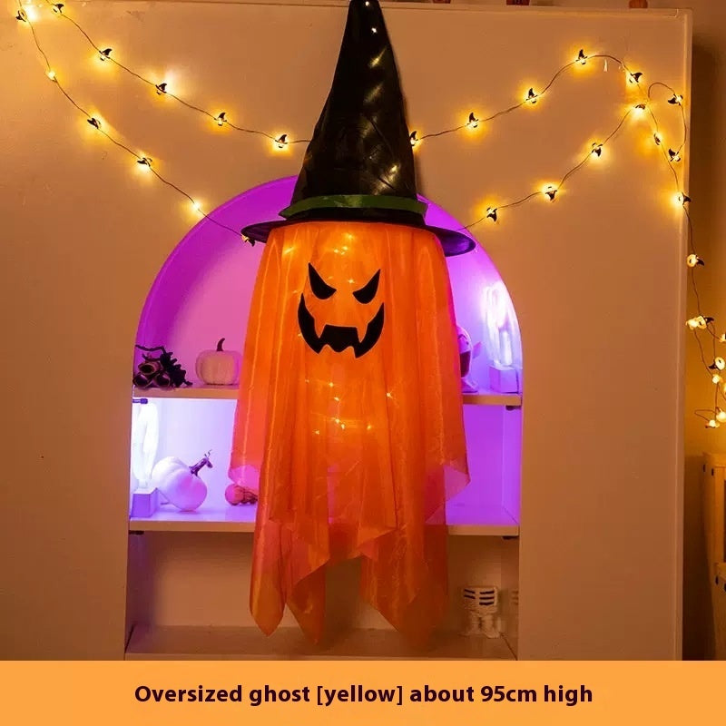 Halloween-themed oversized ghost decoration with a witch hat against a decorated wall.