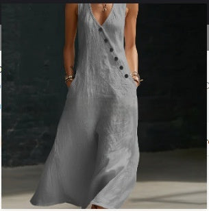 Person wearing a gray dress with black buttons against a dark background