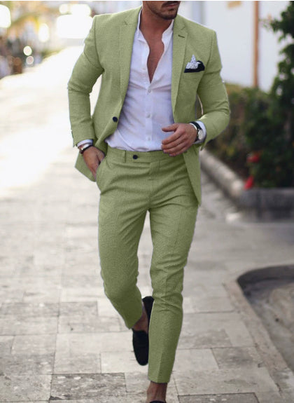 Man wearing a light green suit with a white shirt on a blurred outdoor background