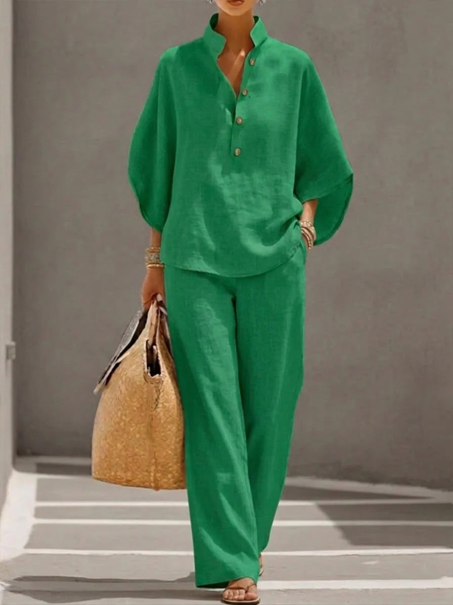 Person wearing a green outfit holding a straw bag on a gray background