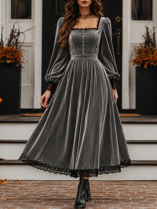 Woman wearing a gray velvet dress with lace details on a staircase.