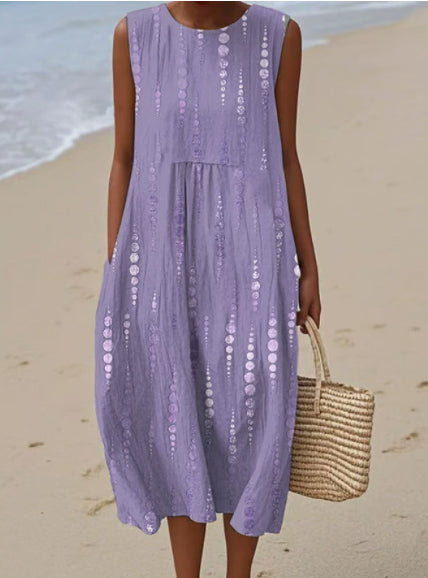 Person wearing a purple dress on a beach with a straw bag.