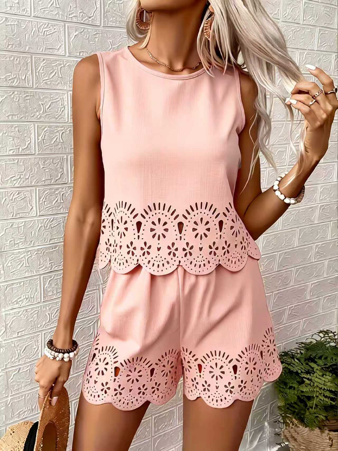 Woman wearing a pink dress with lace details against a textured wall.
