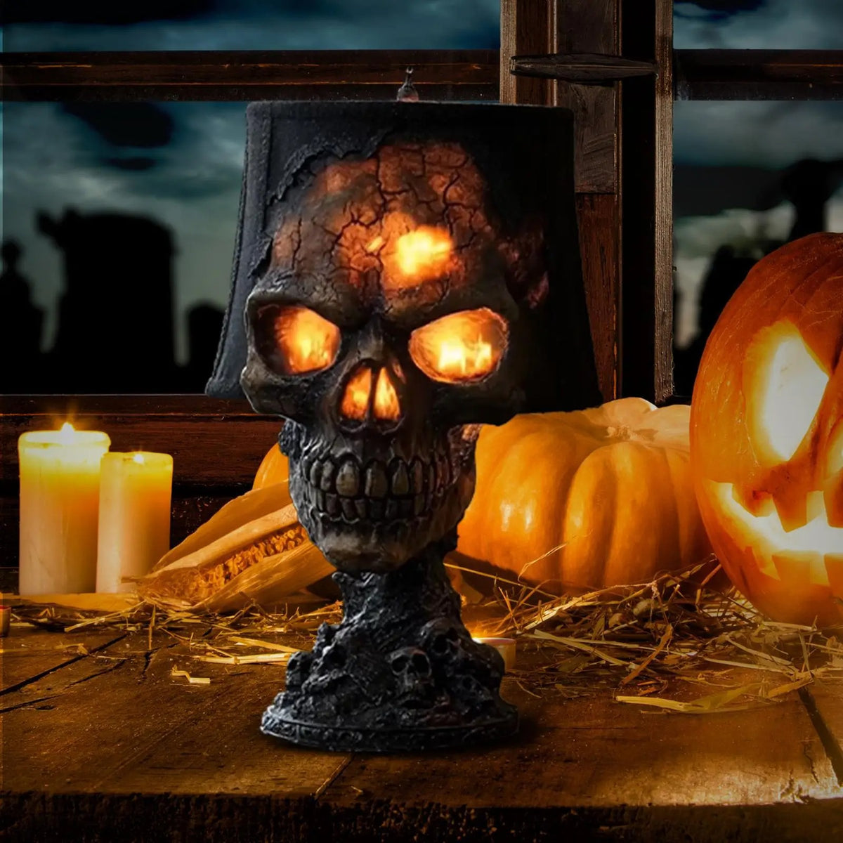 Decorative skull with glowing eyes on a wooden surface with pumpkins and candles, set against a dark sky.