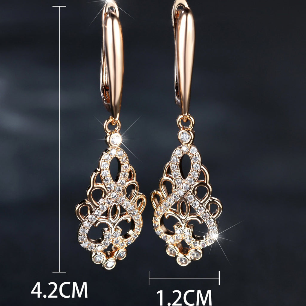Gold earrings with intricate designs on a dark background