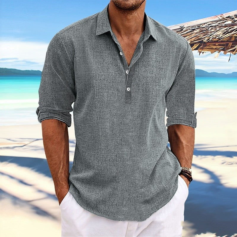 Man wearing a gray short-sleeve shirt on a beach